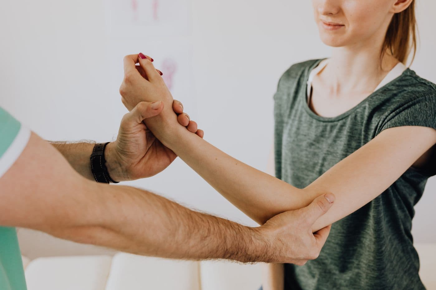 Chiropractor onderzoekt de arm van een patiënt in de praktijk
